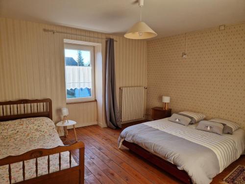 une chambre avec un grand lit et une fenêtre dans l'établissement Gîte HAUTEROCHE BOISSON, à Crançot