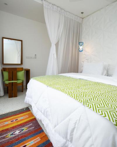 a bedroom with a large bed and a mirror at Amkia Villas Diani in Diani Beach