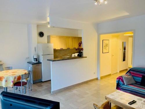Il dispose d'une cuisine et d'un salon avec un canapé et une table. dans l'établissement Appartement F2 moderne avec wifi et garage à Amélie-les-Bains - FR-1-703-110, à Amélie-les-Bains-Palalda