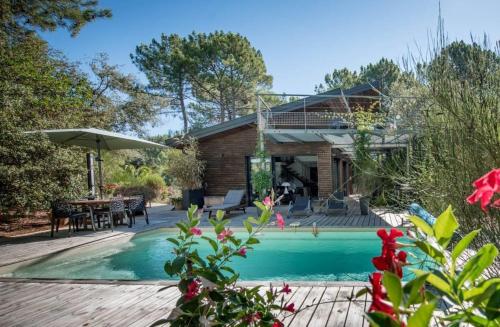 une maison avec une piscine et une terrasse dans l'établissement Arcachon-Moulleau Belle villa avec piscine et jardin privés, à La Teste-de-Buch