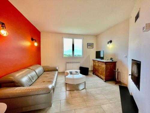 un salon avec un canapé et une télévision dans l'établissement Maison de famille Henvic, à Henvic