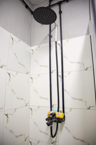 un trapeador colgando de la pared en una ducha en Shkodra Hostel & Day Tours, en Shkodër