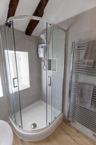 a shower with a glass door in a bathroom at FRANCE FOLD COTTAGE - Cosy 1 Bed Cottage Close to Holmfirth & the Peak District, Yorkshire in Honley