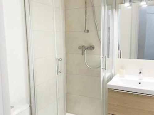 une salle de bain blanche avec une douche et un lavabo dans l'établissement Studio climatisé avec terrasse, piscine et parking à La Grande-Motte - 4 pers - FR-1-716-54, à La Grande Motte