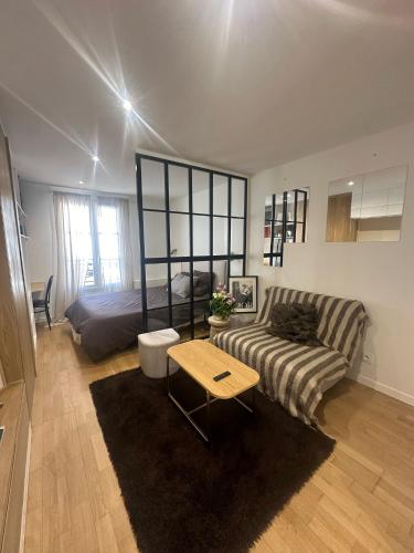 un salon avec un canapé et un lit dans l'établissement Studio champs Elysée, à Paris