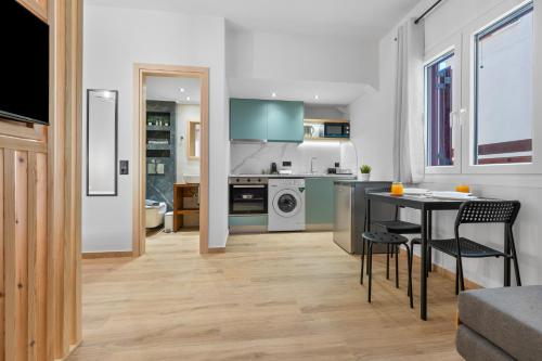 eine Küche und ein Wohnzimmer mit Tisch und Stühlen in der Unterkunft Carina Studios Lefkada 2 in Lefkada Town