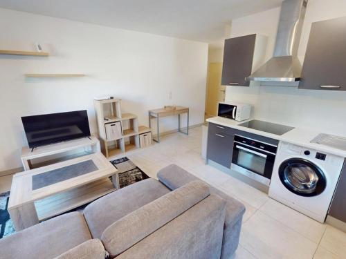 un salon avec un canapé et une cuisine dans l'établissement T2 climatisé avec balcon, garage et wifi - proche mer et gare - FR-1-196-371, à Roquebrune-Cap-Martin