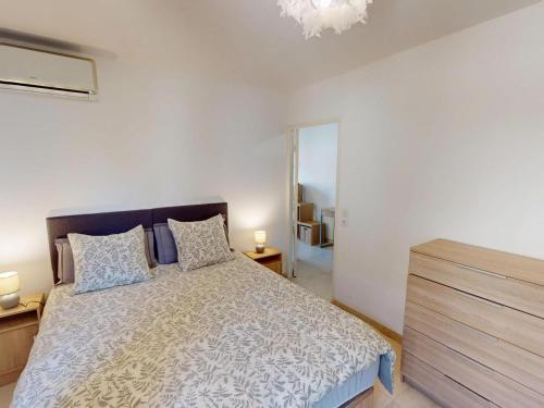 - une chambre avec un lit, deux lampes et un miroir dans l'établissement T2 climatisé avec balcon, garage et wifi - proche mer et gare - FR-1-196-371, à Roquebrune-Cap-Martin