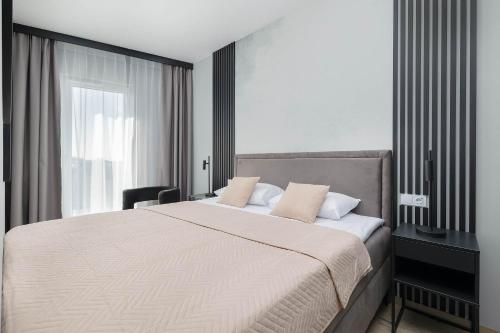 a bedroom with a large bed and a window at Baltic Waves Resort w Międzyzdrojach Blisko Plaży & Parking by Noclegi Renters in Międzyzdroje