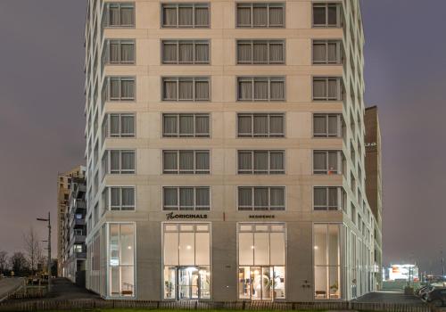 a tall building with glass windows in a city at The Originals Résidence Paris Sud Villejuif in Villejuif