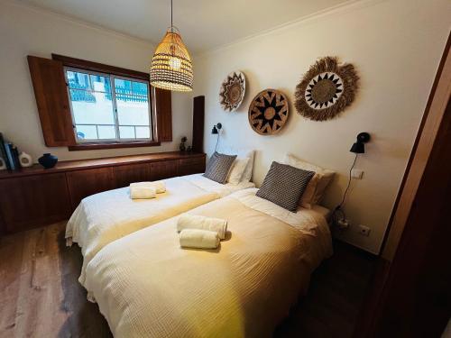 a bedroom with two beds with towels on them at Corn House, São Pedro de Moel Sea View in Marinha Grande