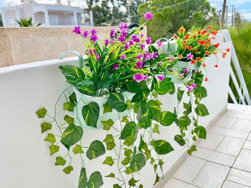 a white planter with flowers and plants in it at BLE, Oneiropagida, Aegina in Vathí