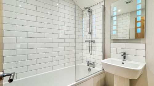 ヘクサムにあるThe Oak Apartmentの洗面台とバスタブのある白いバスルーム