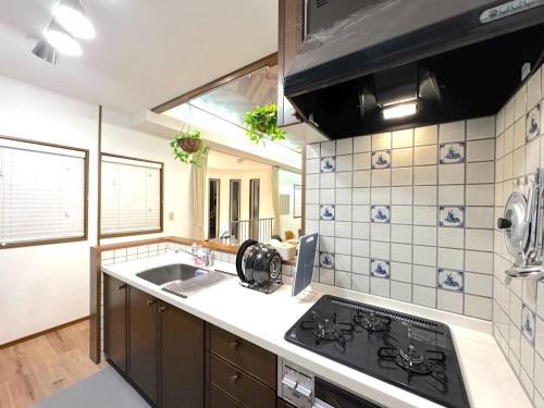 a kitchen with a stove and a sink at Ango Yamanakako2 in Oyama