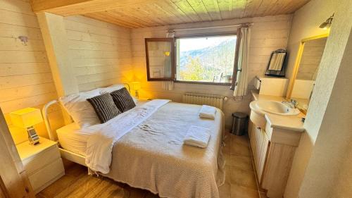 une petite chambre avec un lit et un lavabo dans l'établissement Charmant appartement avec jardin et magnifique vue, à Saint-Jean-de-Sixt