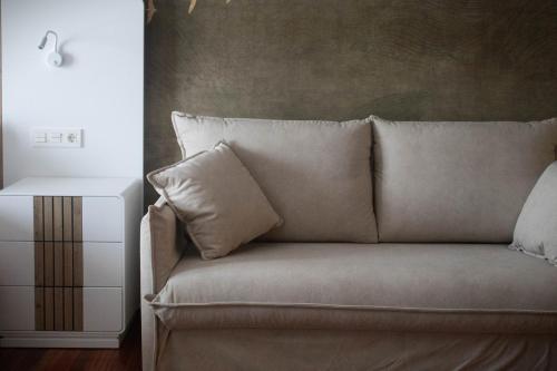 a couch with a pillow next to a side table at Hotel Bermeo in Bermeo
