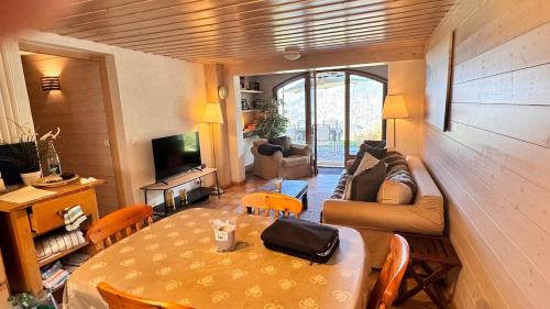 un salon avec une table et un canapé dans l'établissement Charmant appartement avec jardin et magnifique vue, à Saint-Jean-de-Sixt