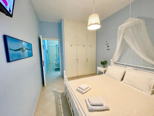 a bedroom with a white bed with towels on it at BLE, Oneiropagida, Aegina in Vathí