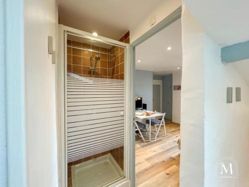 une porte coulissante en verre menant à une chambre avec une table. dans l'établissement Studio climatisé dans le centre-ville de Sanary, à Sanary-sur-Mer