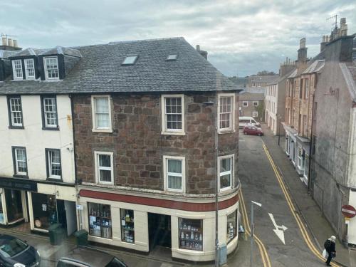 an old brick building on a city street at Spacious 3 bedroom apartment in Campbeltown centre in Campbeltown