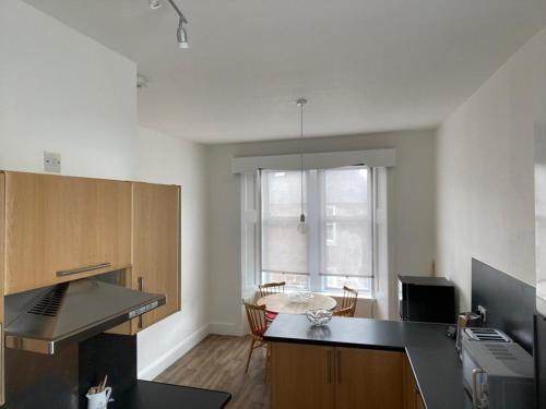 a kitchen with a counter and a table in a room at Spacious 3 bedroom apartment in Campbeltown centre in Campbeltown