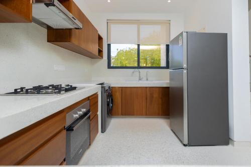 a kitchen with a stainless steel refrigerator and a sink at Amkia Villas Diani in Diani Beach
