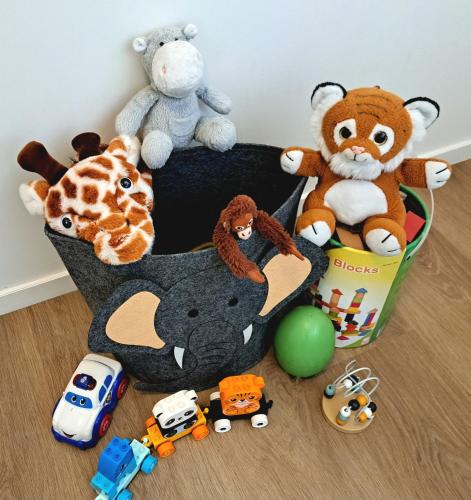 a basket filled with stuffed animals and toys on a floor at Boshuisje op de Schatberg in Sevenum