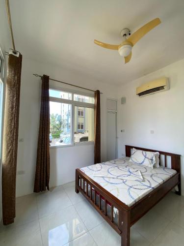 a bedroom with a bed and a window at Zanzibar Manolo Apartment in Zanzibar City