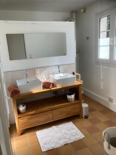 une salle de bain avec deux lavabos et un miroir dans l'établissement Charmante villa 3 Chambres 1 mezzanine, à Hourtin