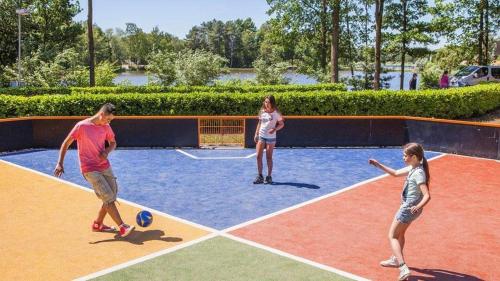 a group of people playing a game on a tennis court at Boshuisje op de Schatberg in Sevenum