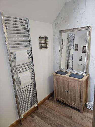a bathroom with a large mirror and a wooden vanity at Letterfinlay Lodge House in Letterfinlay