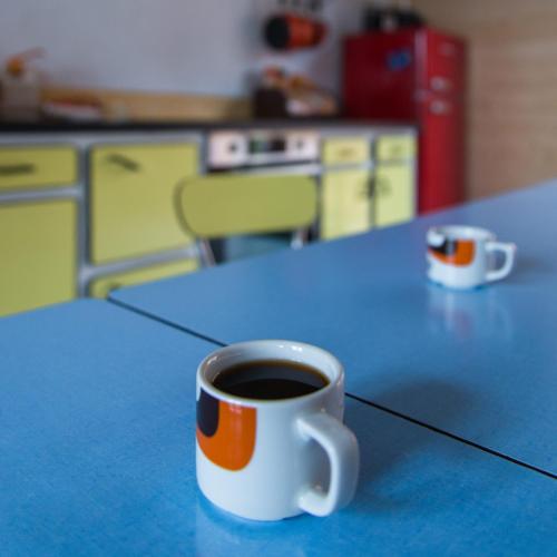- une tasse de café assise sur une table bleue dans l'établissement So Vintage - Gite seventies en Anjou, à Sermaise