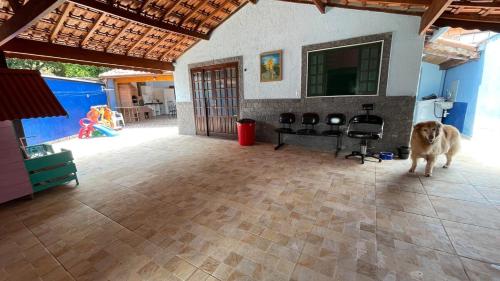 a dog standing in the middle of a living room at Casa Temporada - Centro Guararema SP in Guararema