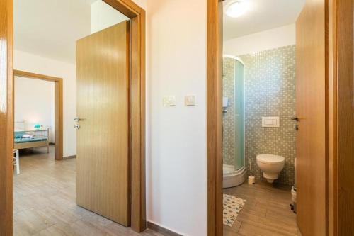 a bathroom with a toilet and a shower and a door at Apartments Garden in Jurandvor