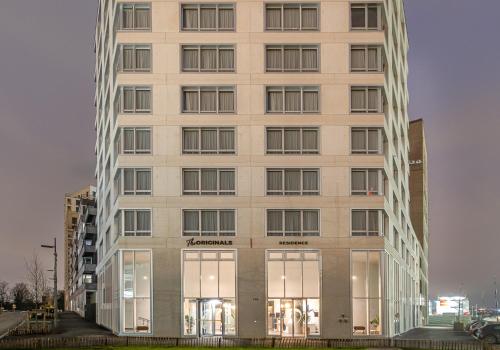 a tall white building with glass windows at The Originals Résidence Paris Sud Villejuif in Villejuif