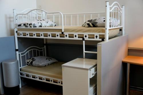two bunk beds in a room with a desk at YOUR HOSTEL midi station in Brussels