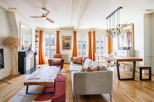 un salon avec un canapé et une table dans l'établissement Appartement Collette - Welkeys, à Paris