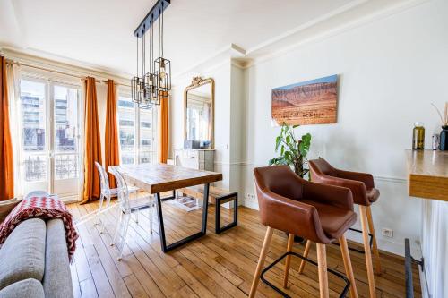 un salon avec une table et un canapé dans l'établissement Appartement Collette - Welkeys, à Paris