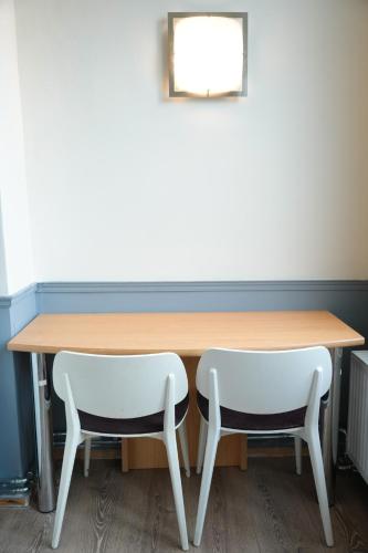 a table with two white chairs sitting next to it at YOUR HOSTEL midi station in Brussels