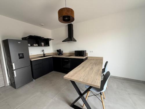 a kitchen with a wooden table and a refrigerator at E casette in Oletta