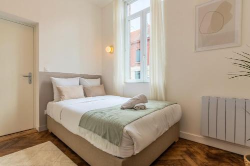 une chambre avec un grand lit avec une fenêtre dans l'établissement Studio fonctionnel pour une personne, proche tram, à Tourcoing