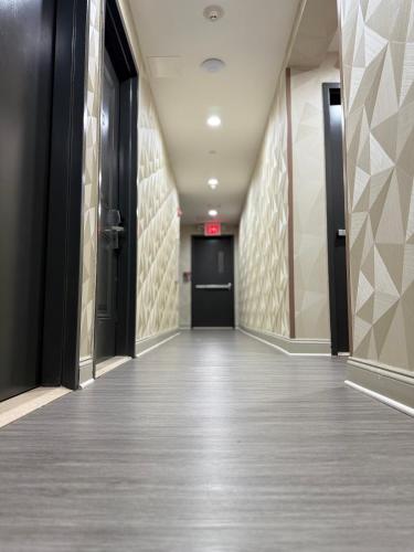 an empty hallway in a building with black doors at Grandview Hotel New York in Queens