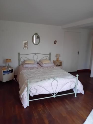 a bedroom with a bed and a wooden floor at Gite du vieil acacia in Celles