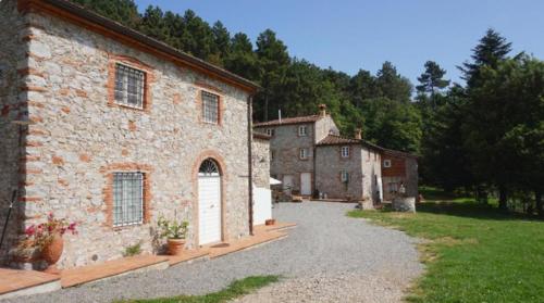 a large stone building with a driveway in front of it at Agriturismo le Vallilunghe in Chiatri