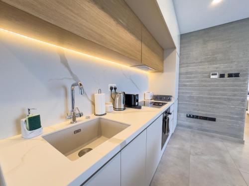 a kitchen with a sink and a counter top at Malberry Park 301 - Modern 2bedroom Apt with Shared Heated Pool, Sauna, Gym, Jacuzzi in Paphos City