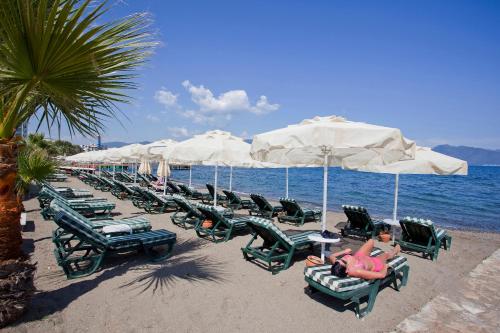 a row of lounge chairs and umbrellas on a beach at Örsmaris Boutique Hotel in Marmaris