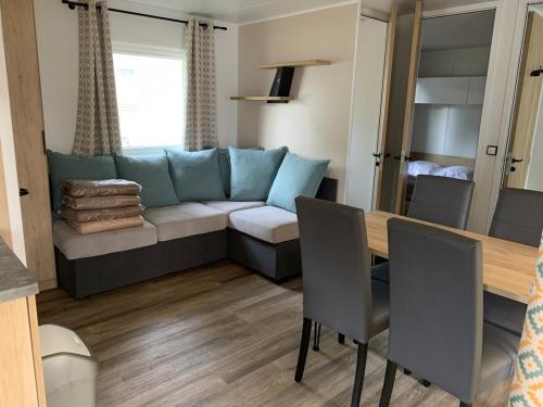 un salon avec un canapé et une table dans l'établissement Mobilhome au bassin d'Arcachon, à Lège-Cap-Ferret