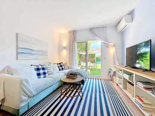 a living room with a couch and a tv at Mar Blau Estartit Rental in L'Estartit
