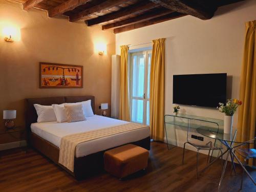 a bedroom with a bed and a flat screen tv at Loger Confort Residence & Apartments in Turin