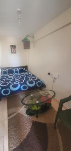 a bedroom with a bed and a table on the floor at Premier BnB in Meru